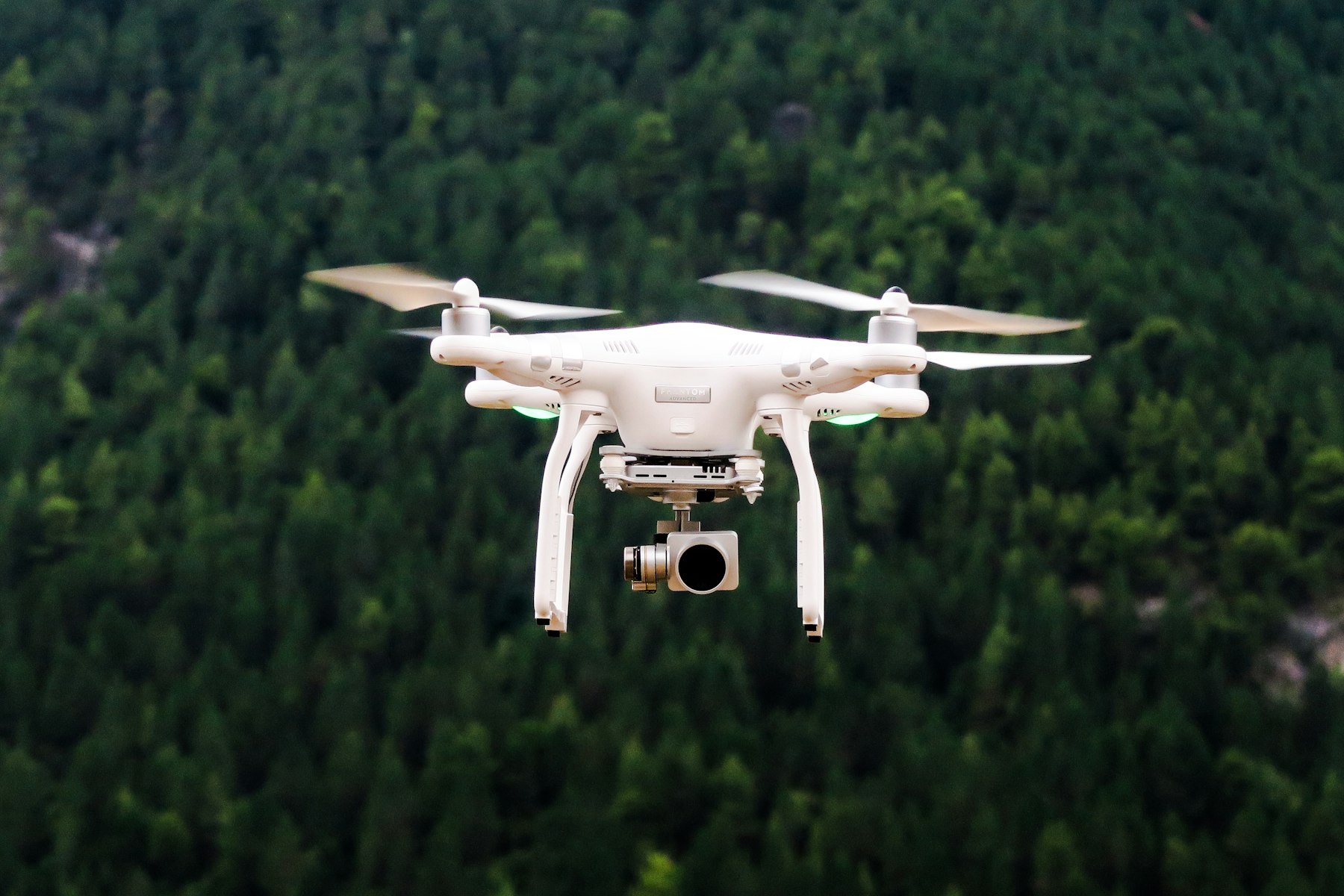 A KVANT aerial unit in flight above a forested inspection corridor