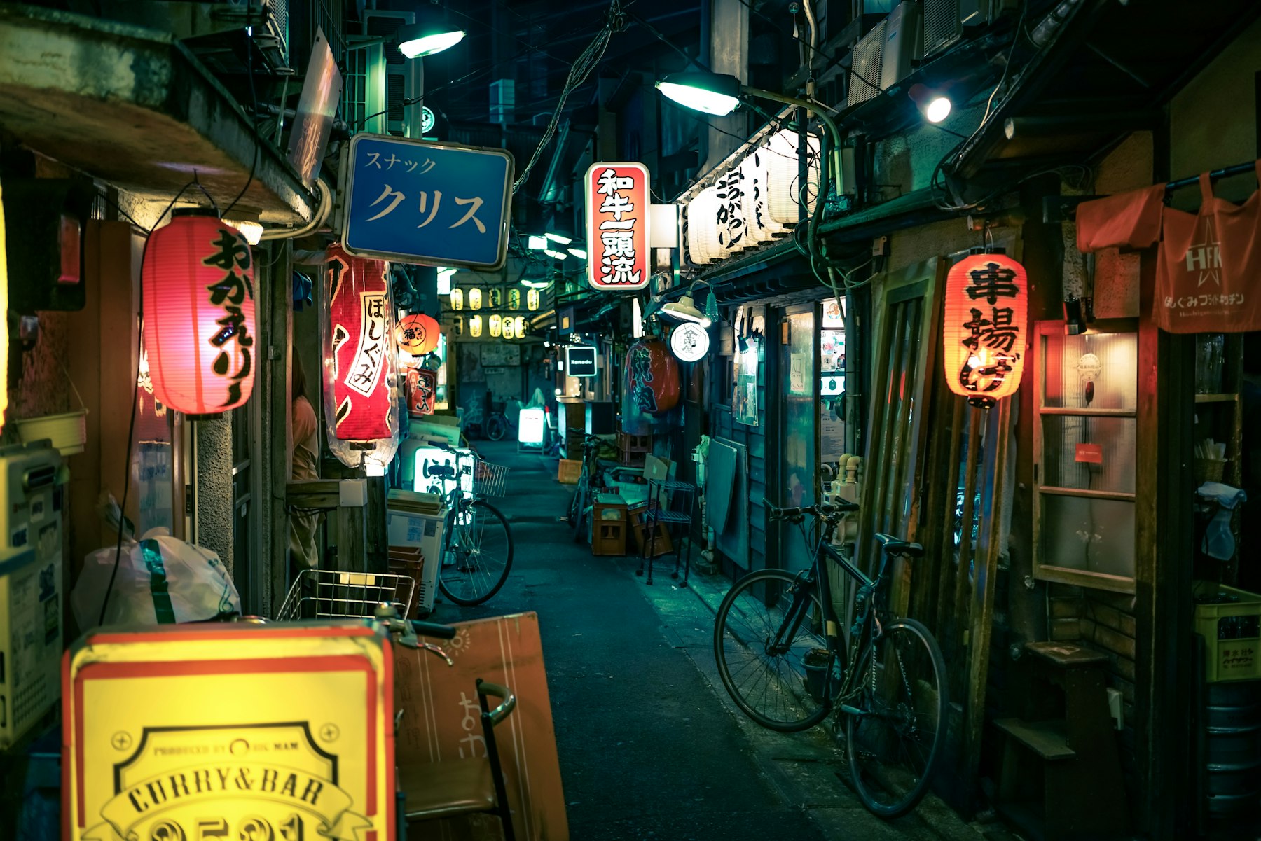 A narrow izakaya alley strung with lanterns at night