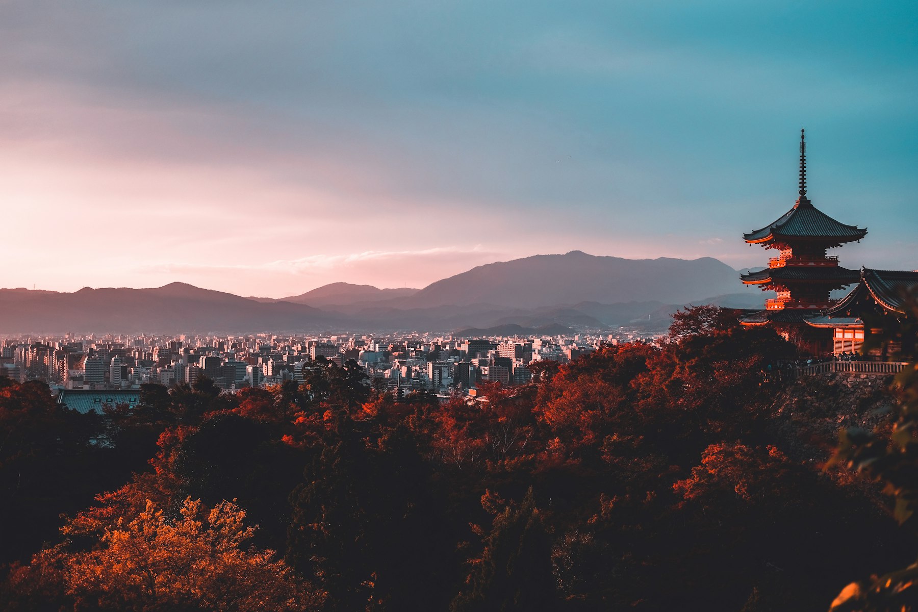 Kyoto at dusk, a pagoda rising over autumn-coloured trees