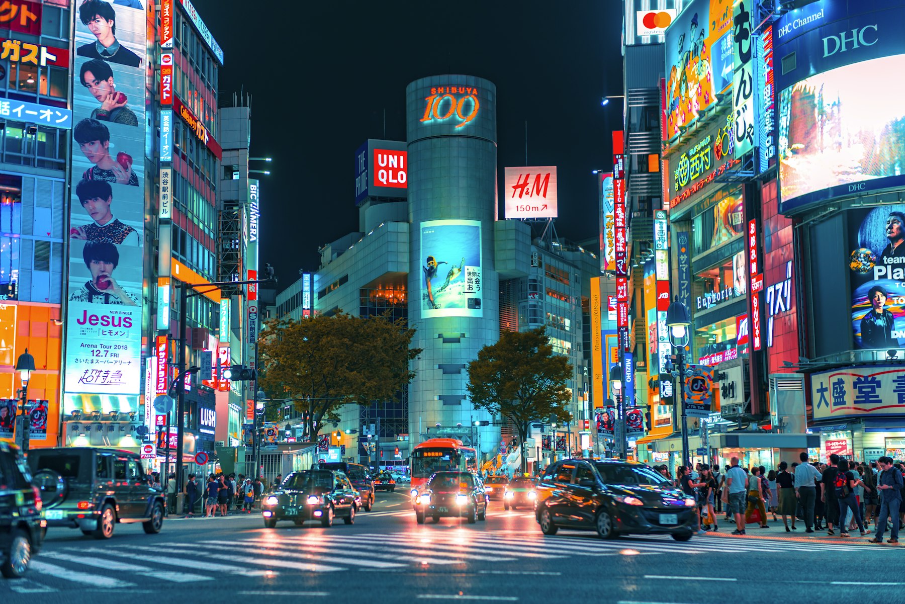Shibuya crossing under walls of neon signage