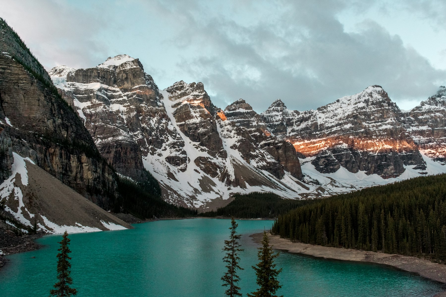 Glacial blue water beneath mountains