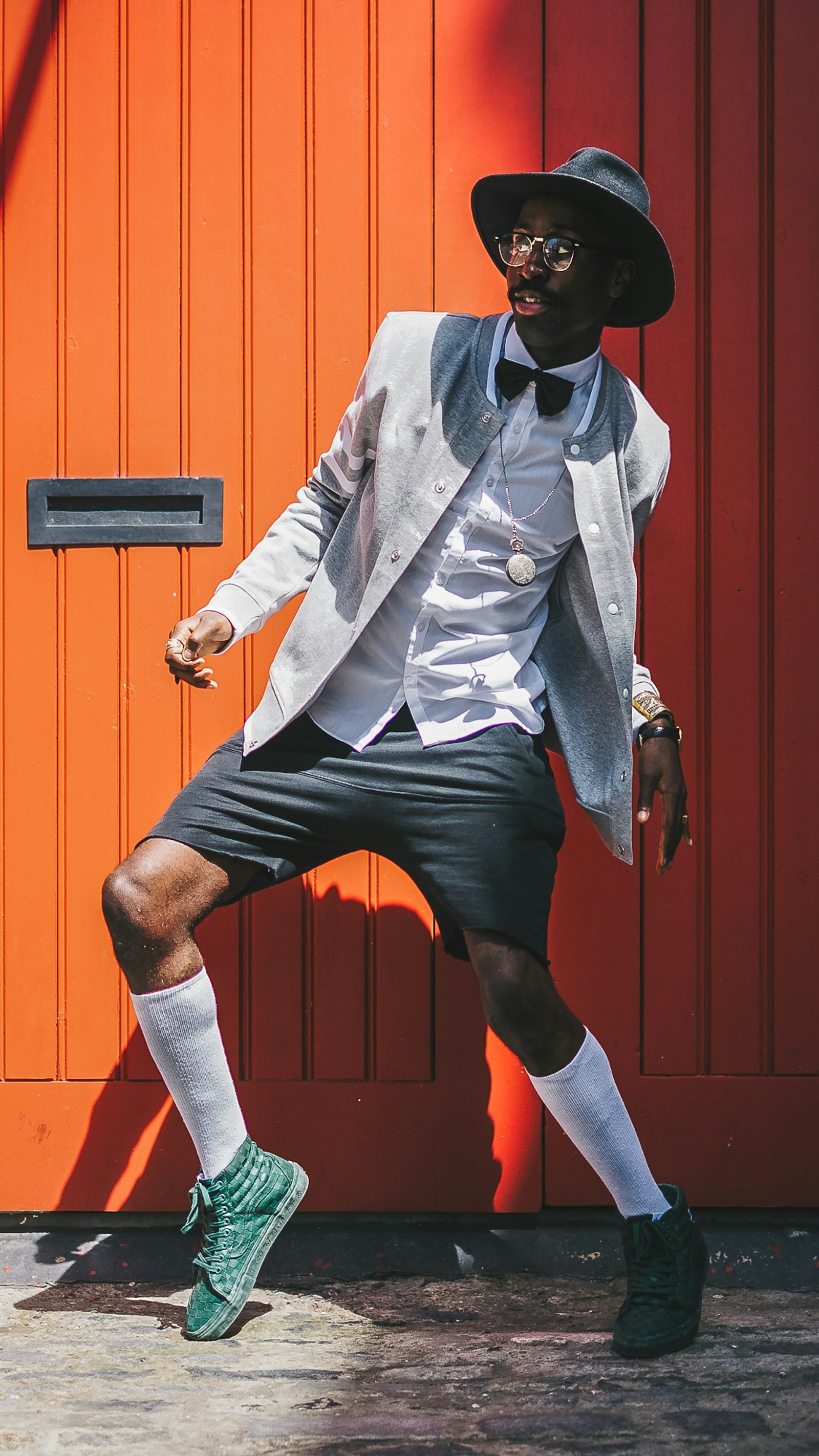 Silver evening suit against an orange wall
